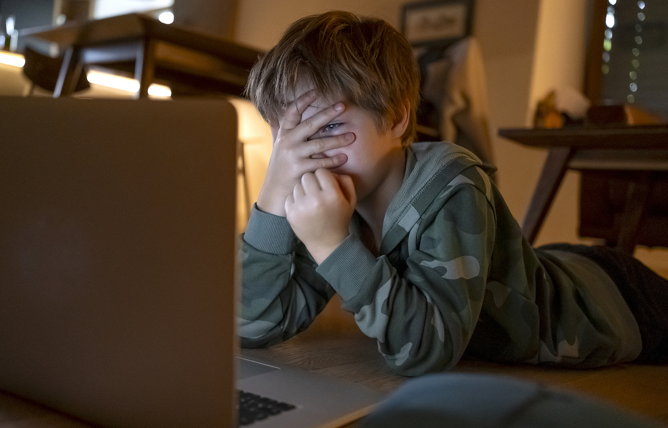 Young kid looking movies on the laptop